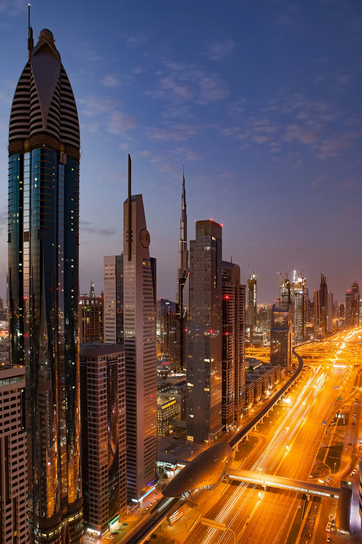 Downtown Dubai towers and the Burj Khalifa lit up at dusk